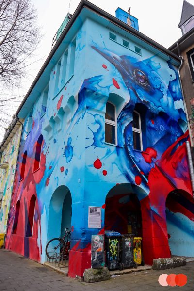 Blauer Vogel auf Häuserwand, Urban Art Düsseldorf
