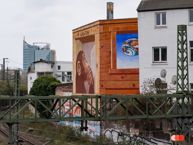 Klaus Klinger-muurschildering "Wat moeten we doen?"bedachtzame aap op het treinstation in Düsseldorf